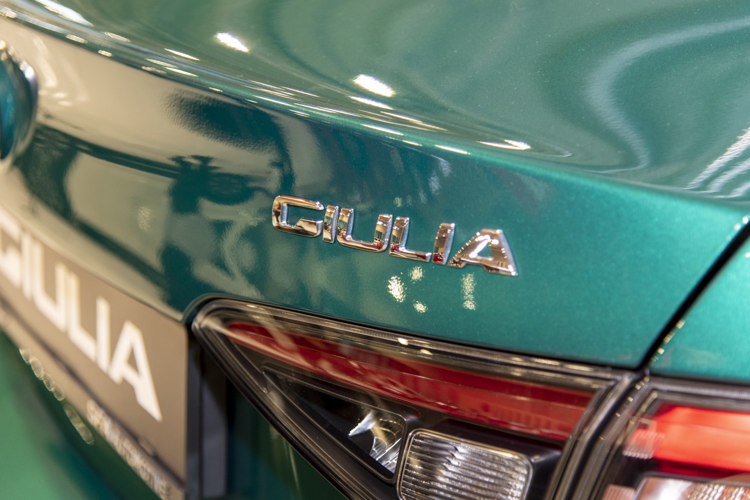 Rear badge and taillight details on a metallic green car