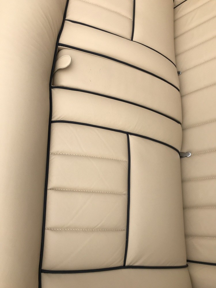 Beige leather seat upholstery with black piping detailing