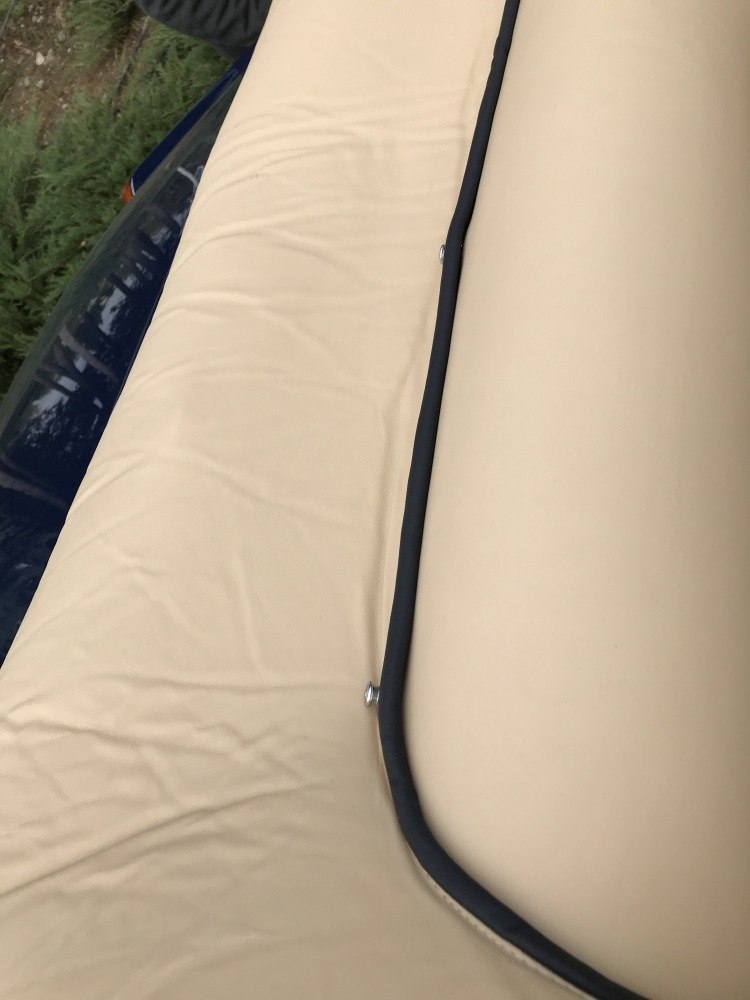 Beige leather upholstery with black piping detail