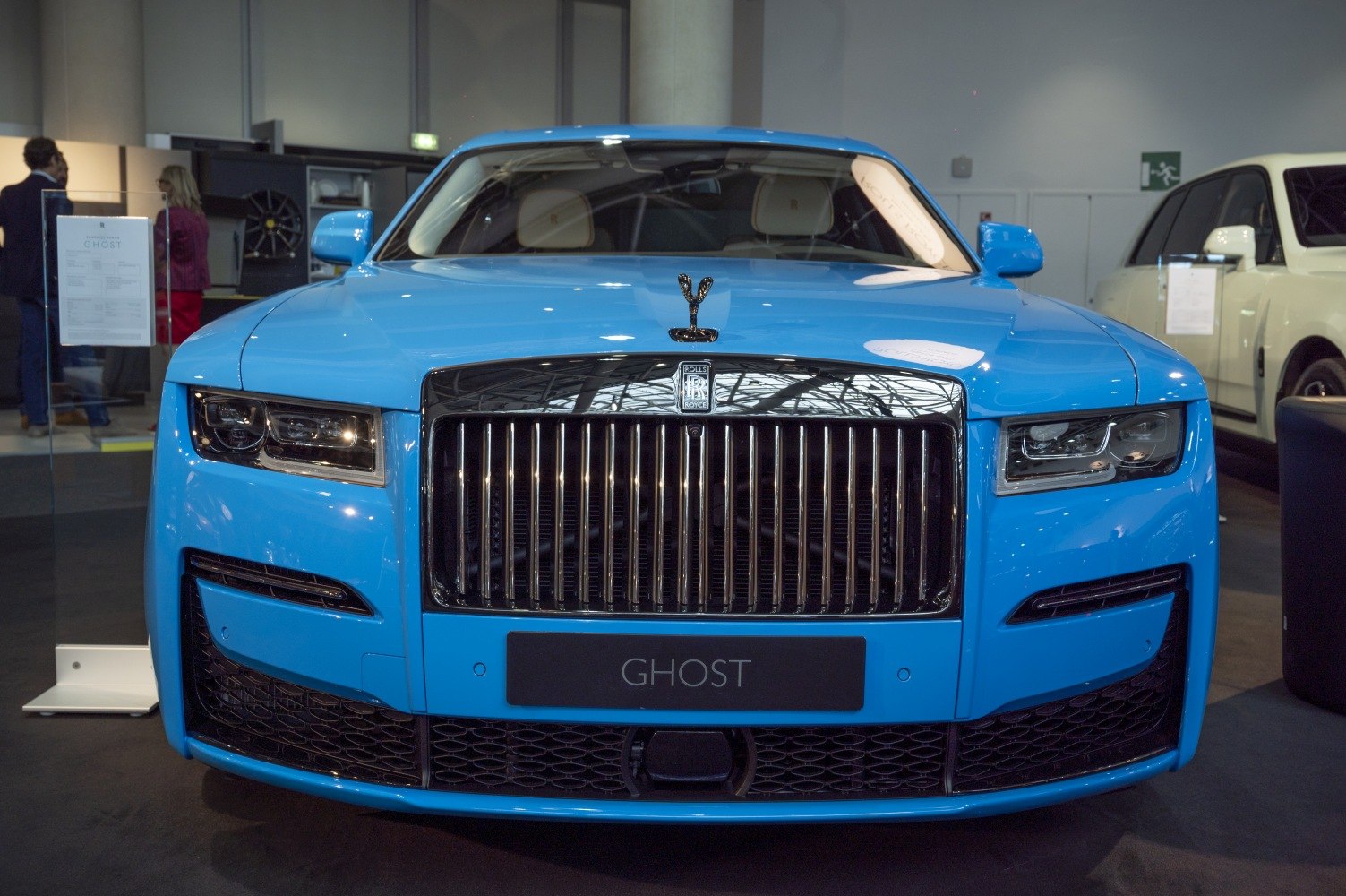 Large chrome grille and rectangular headlights of a luxury car front.