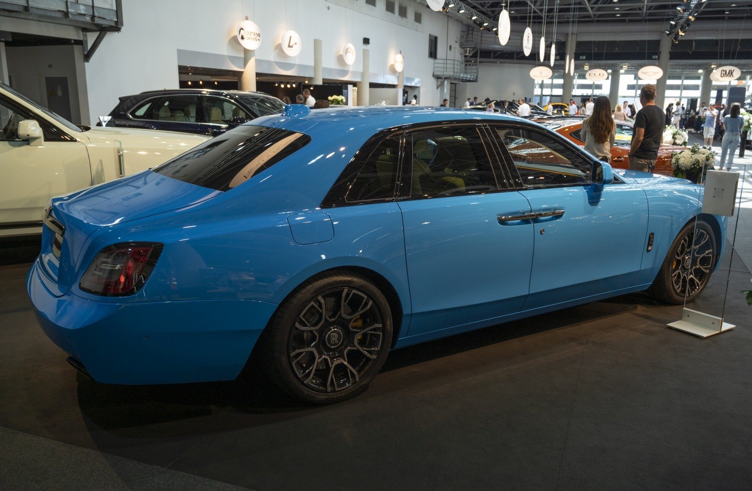 Blue luxury sedan rear and side profile with distinctive wheels