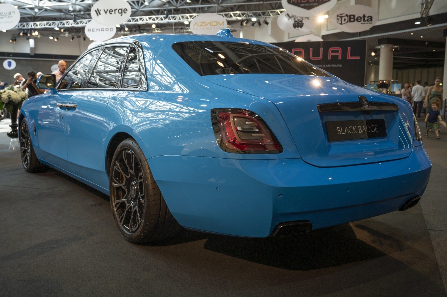 Blue luxury sedan rear with black wheels and tinted windows