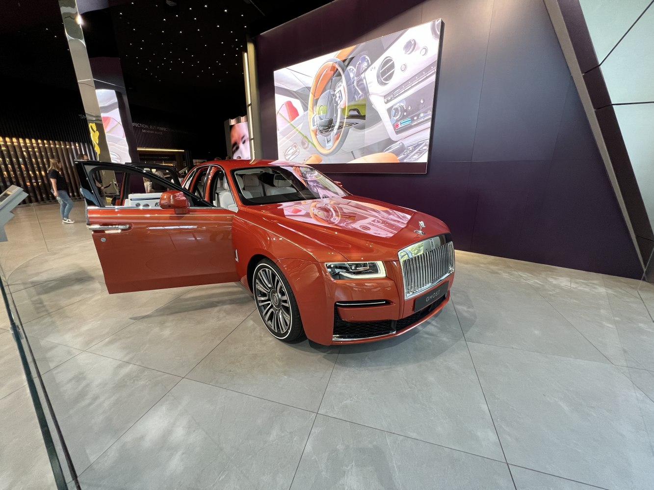 Orange luxury sedan front grille and open door