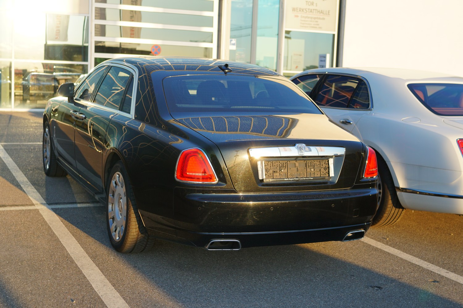 Rear view with iconic tail lights and dual exhaust of luxury sedan