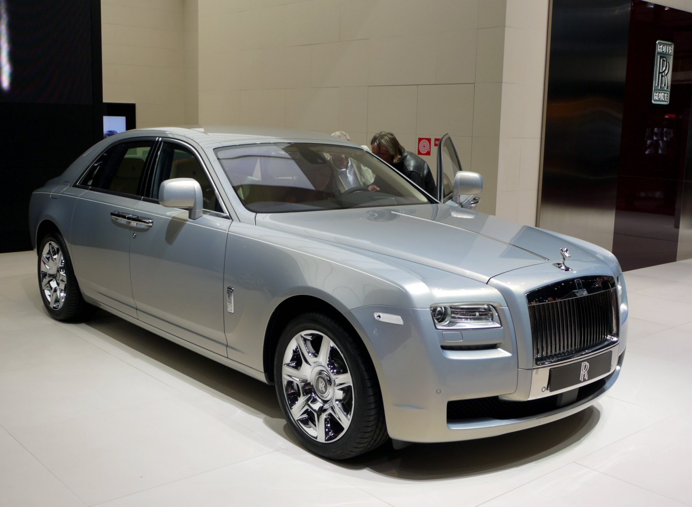 Silver luxury sedan front three-quarter view with distinctive grille and shiny rims
