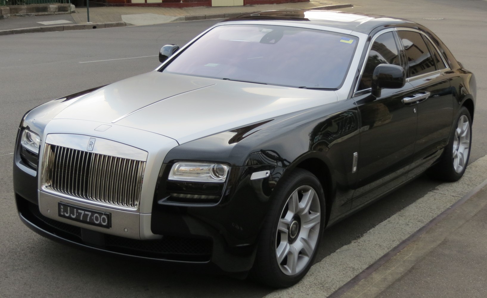 Front grille with vertical bars and LED headlights of luxury sedan.
