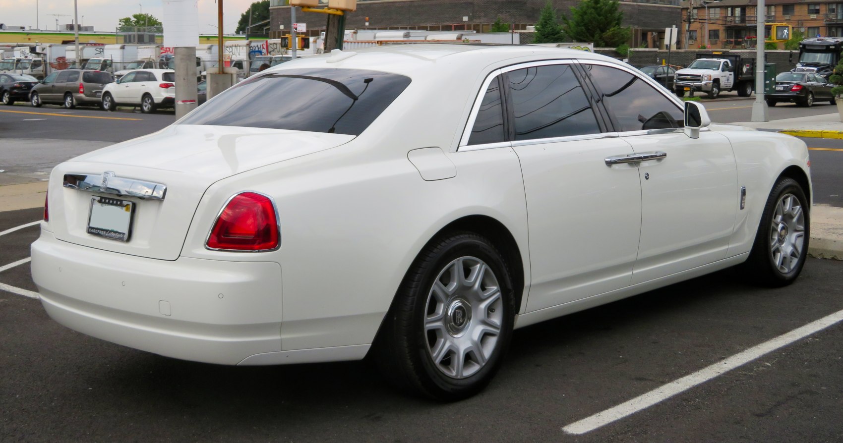 Rear quarter view of a luxury sedan with prominent tail lights and chrome trim