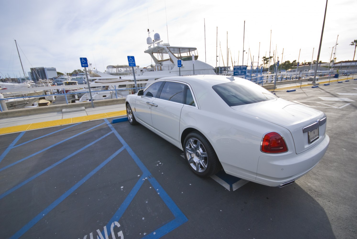 Luxury white sedan rear 3/4 view with chrome wheels