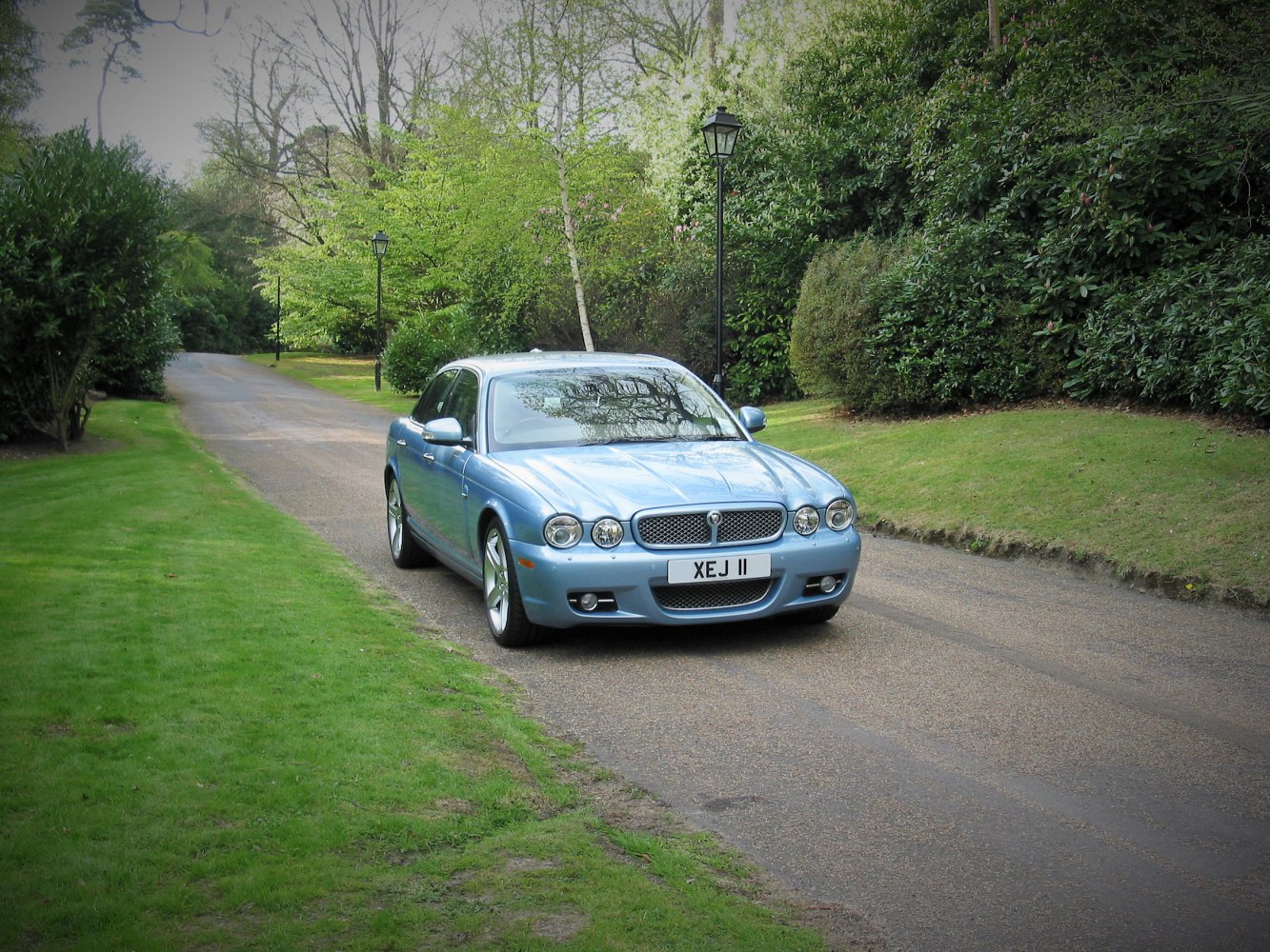 Front view of luxury sedan with quad round headlights and mesh grille
