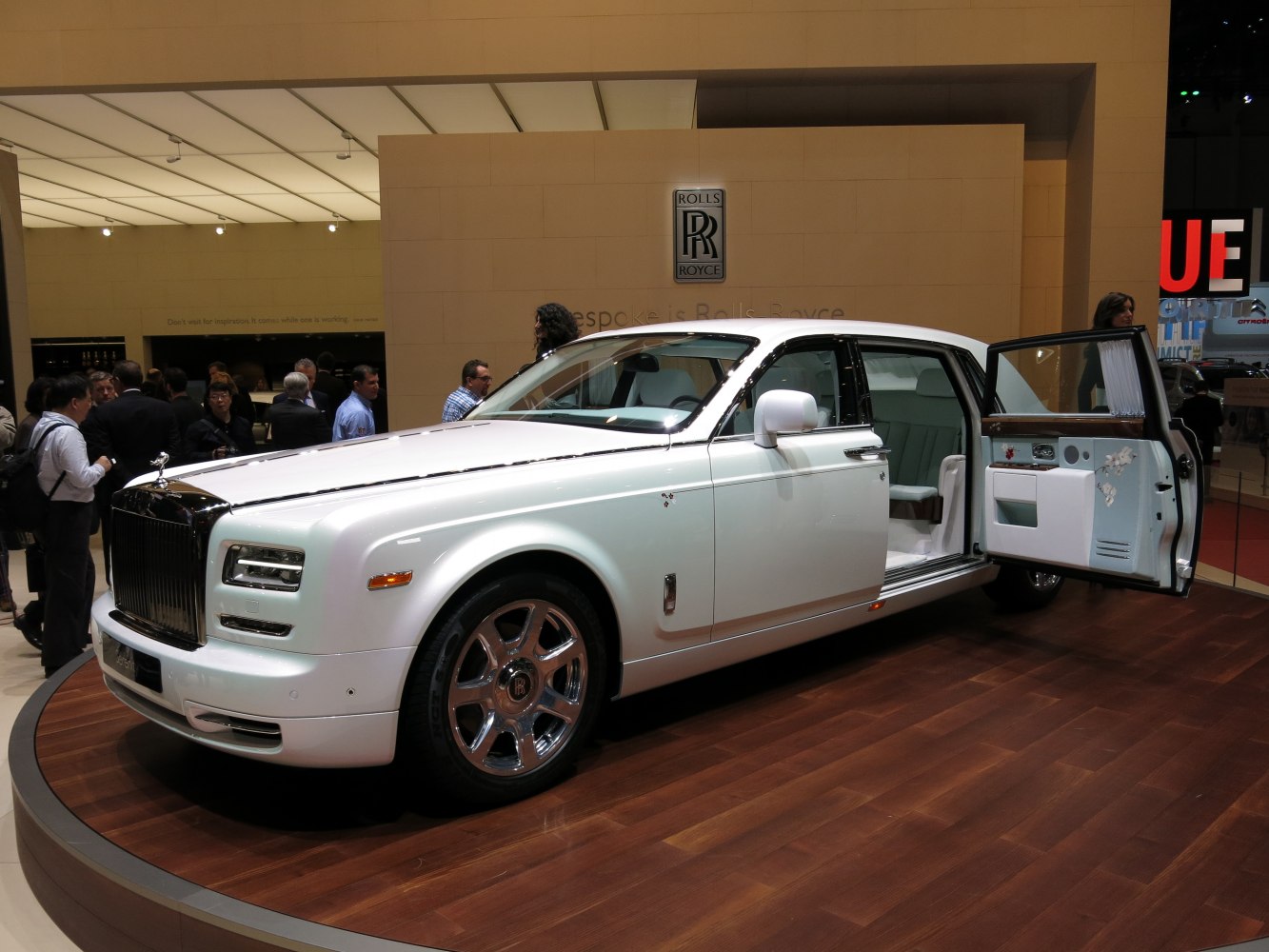 White extended wheelbase luxury sedan with open rear door and chrome wheels