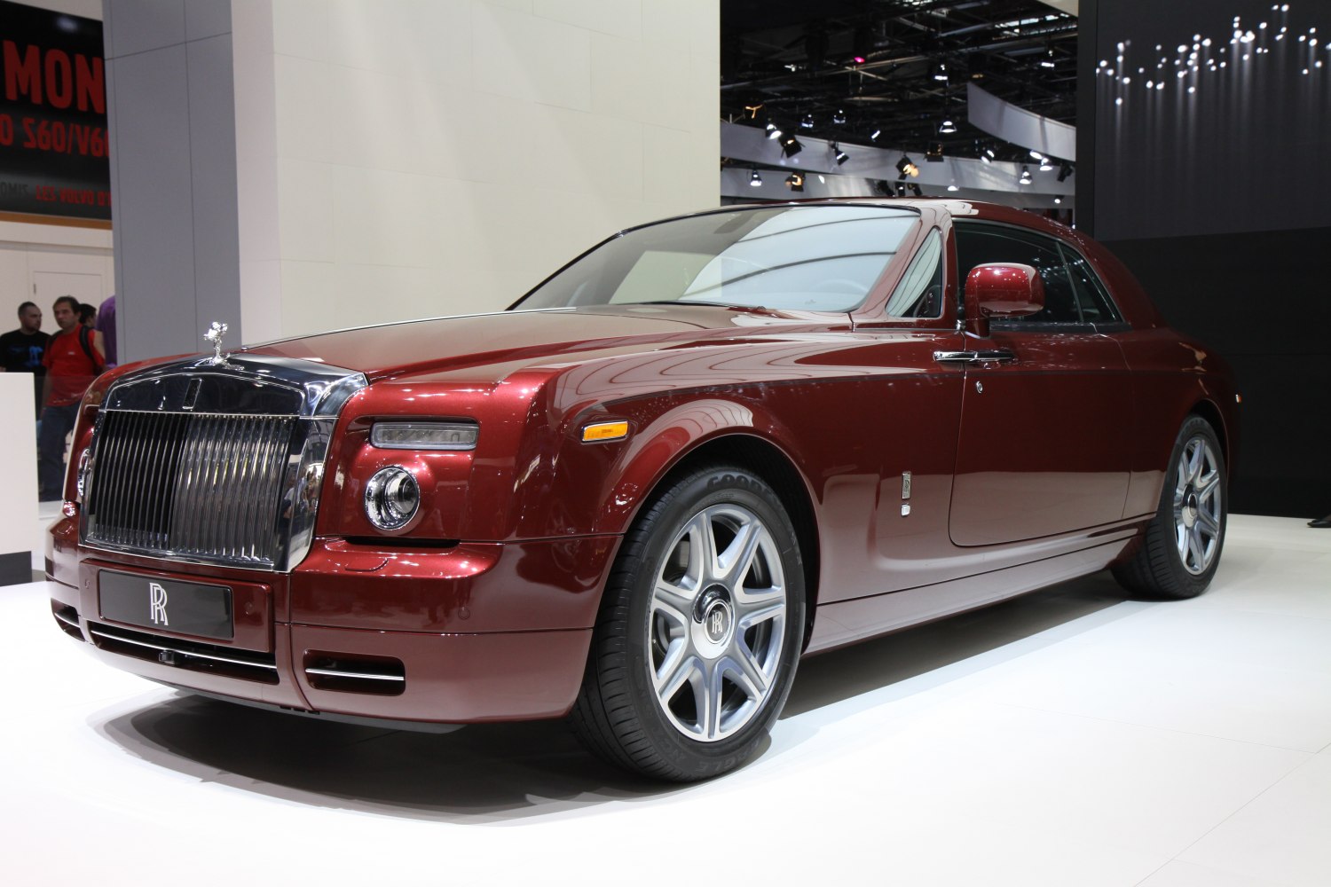 Front angle of luxury coupe with chrome grille and metallic burgundy paint