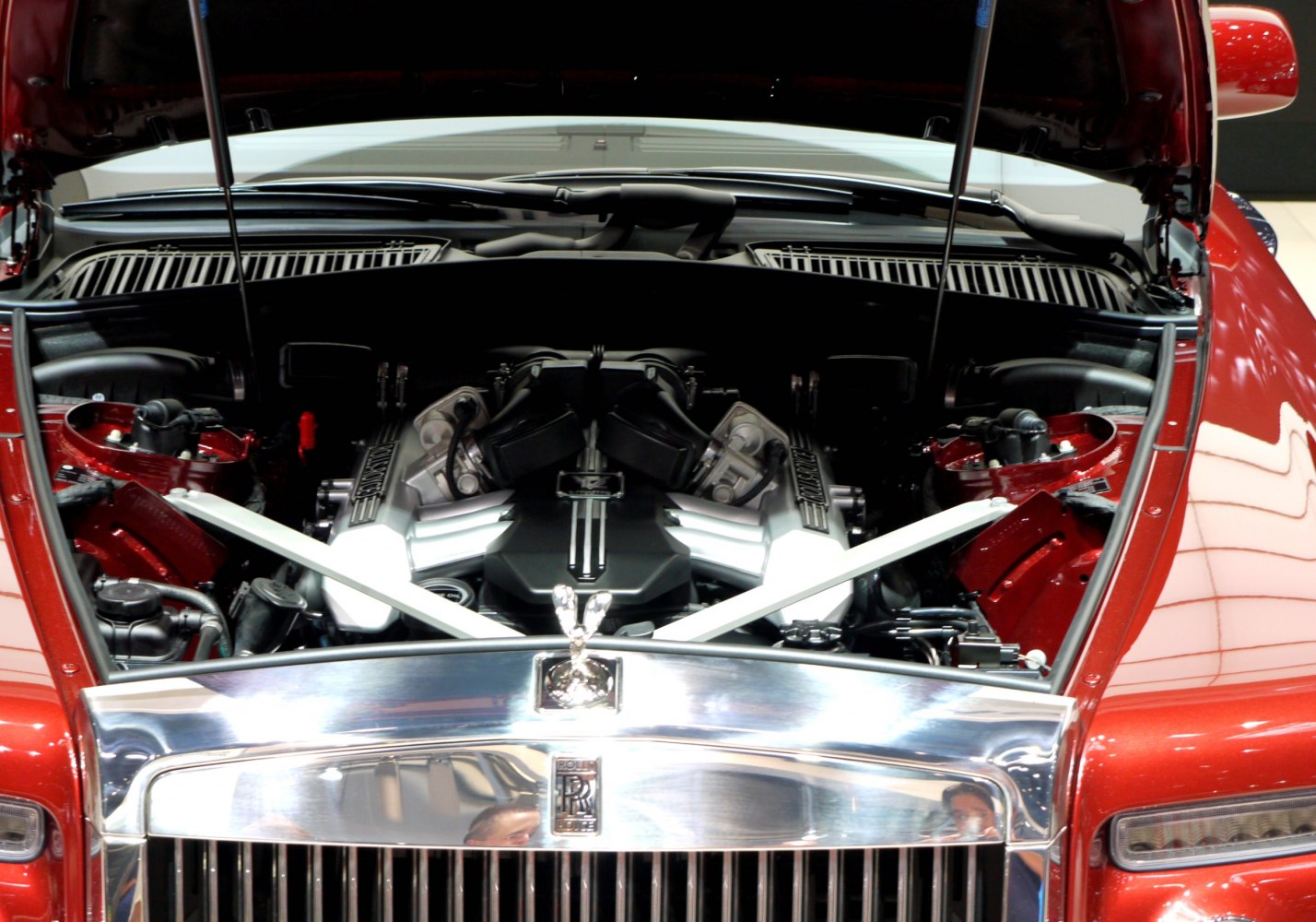 Open hood showing a detailed V12 engine with polished components and structural braces.