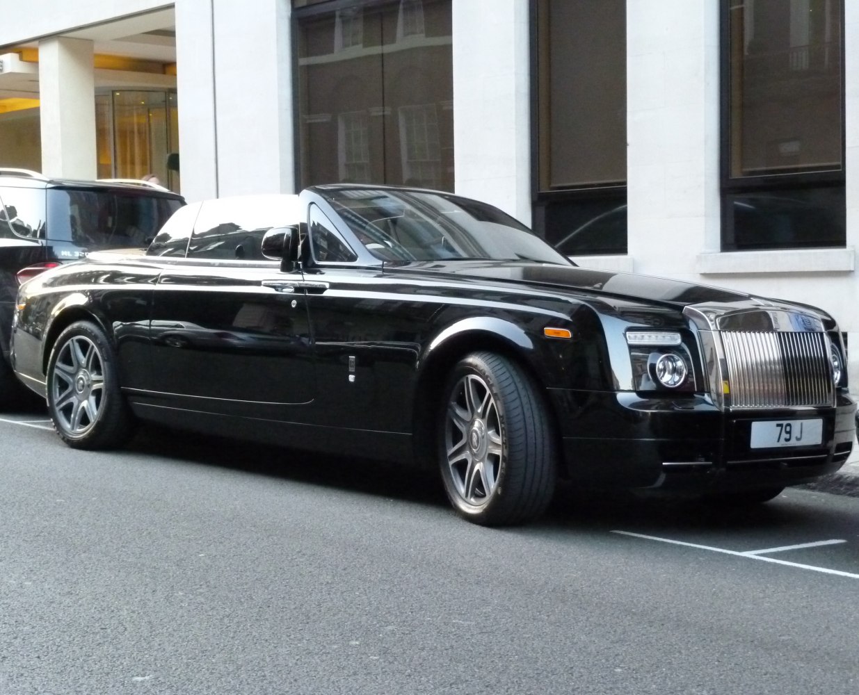 Black luxury convertible with vertical grille and alloy wheels