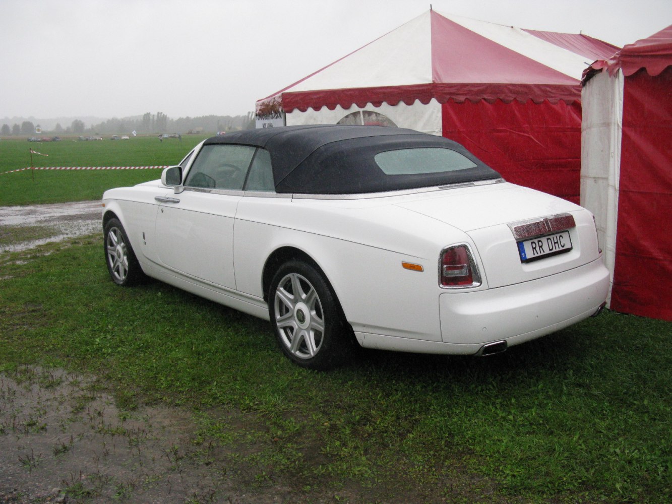 Rear three-quarter view of luxury convertible with black soft top roof and rear lights