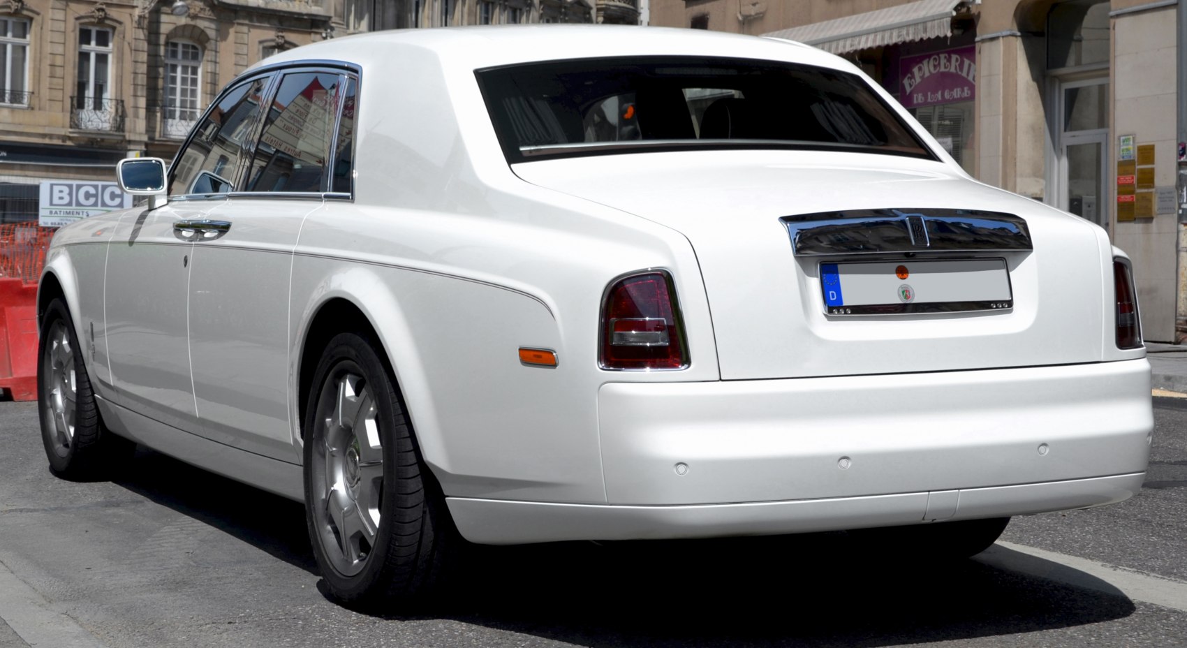 Rear view of luxury white sedan with chrome details and classic taillights