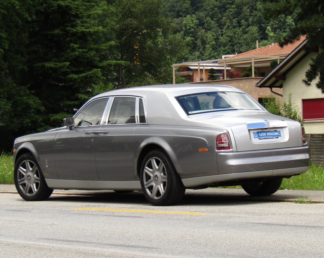 Silver luxury sedan rear side view with chrome trim and distinctive tail lights