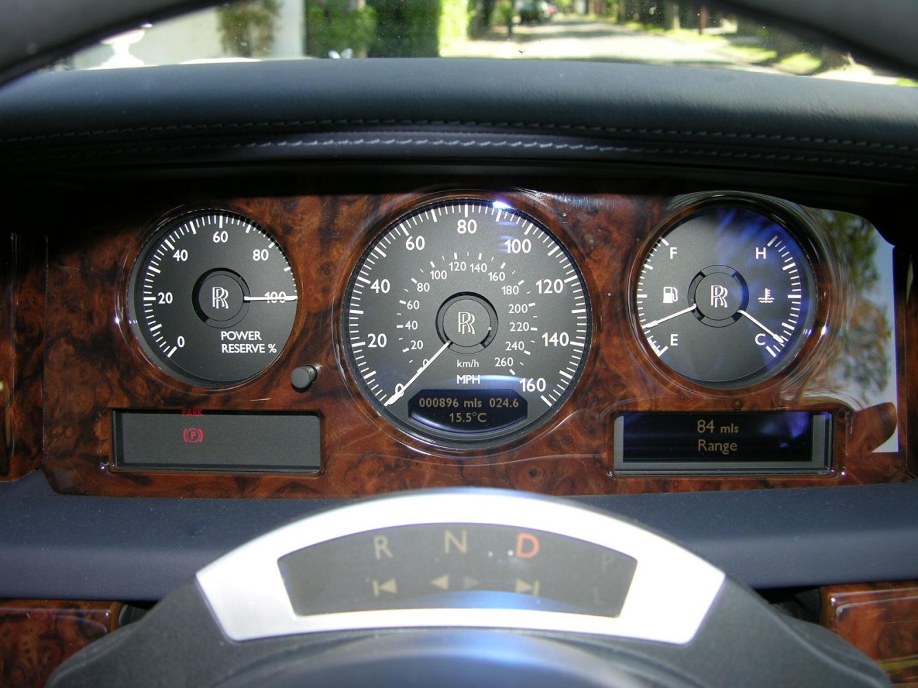 Luxury wood-trimmed instrument cluster with analog gauges and digital displays