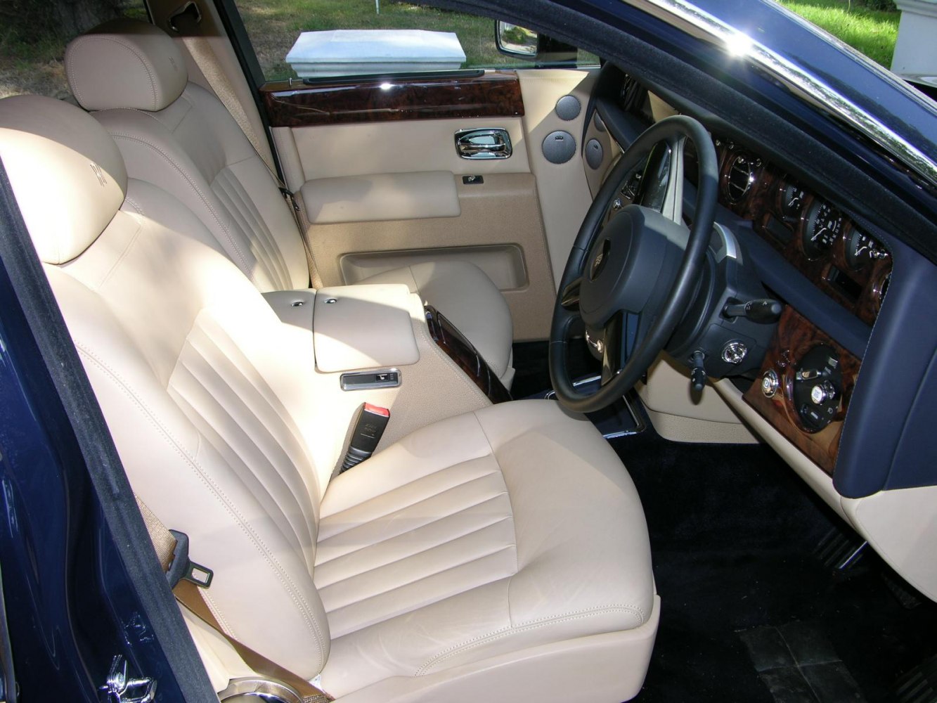 Cream leather seats with wood trim and detailed dashboard