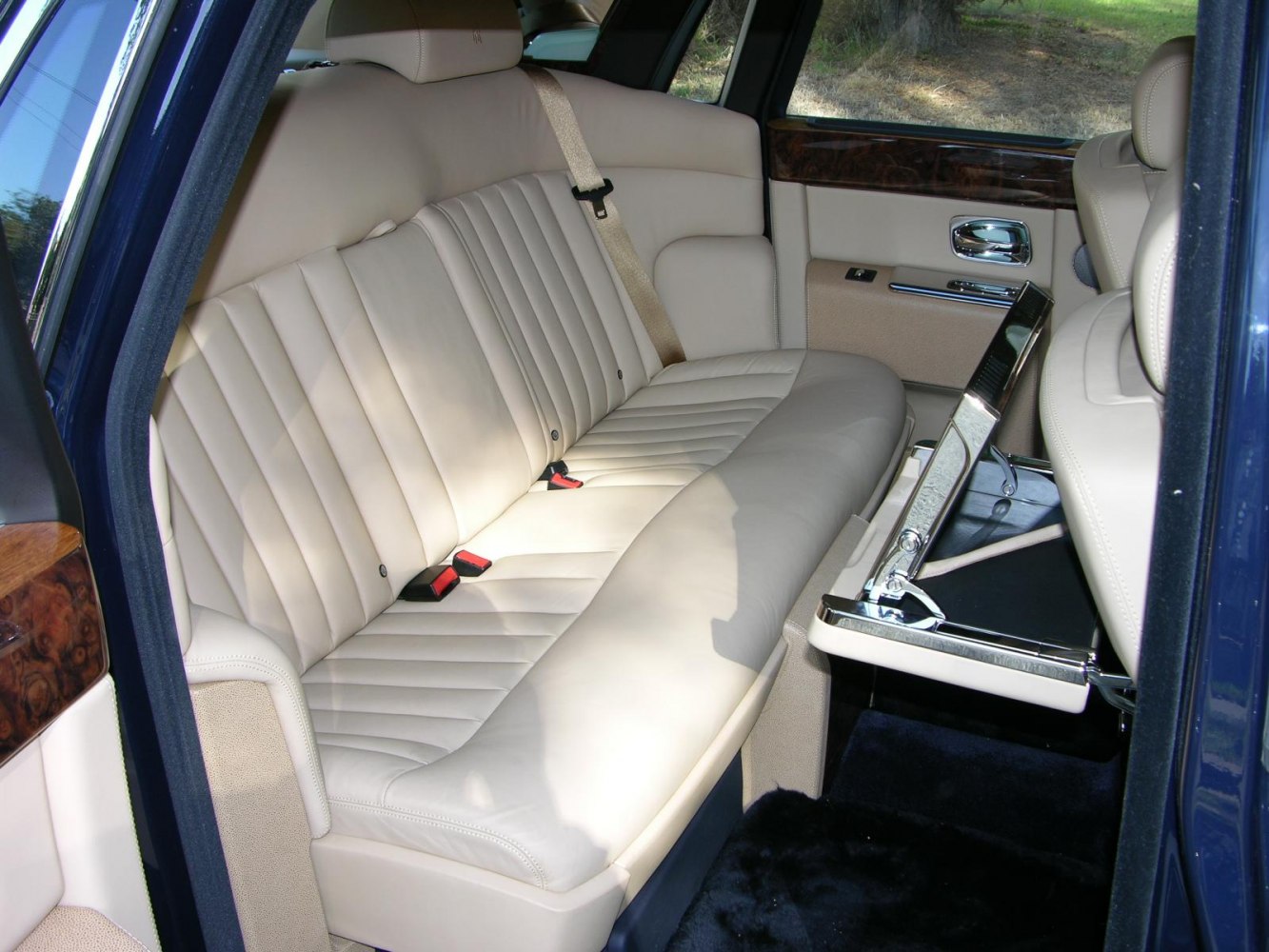 Cream leather rear seat with foldable table and wood trim