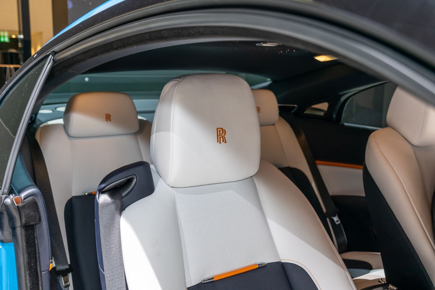 White leather seats with embroidered headrests and detailed stitching