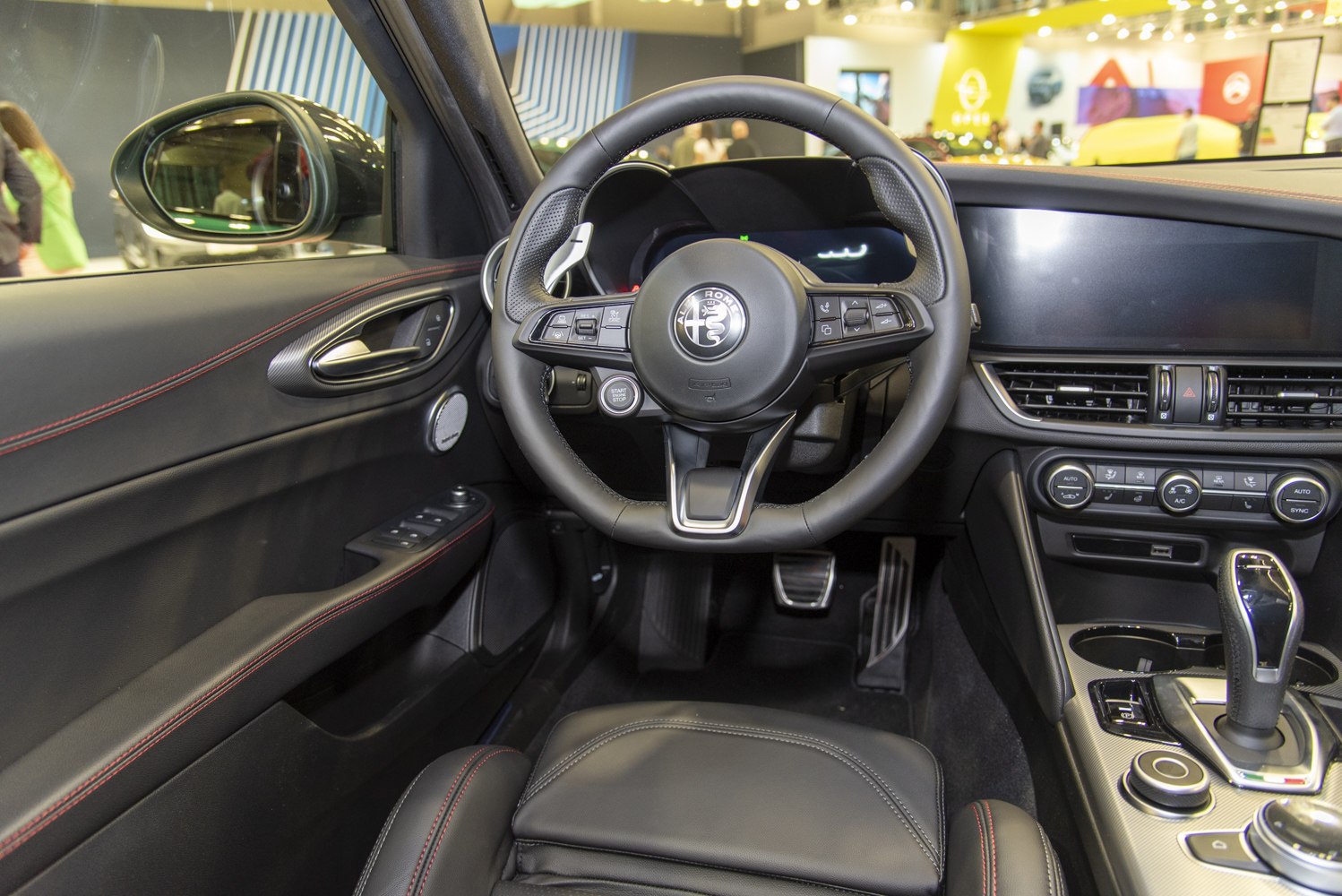 Sporty steering wheel and modern dashboard layout with infotainment system and control buttons.