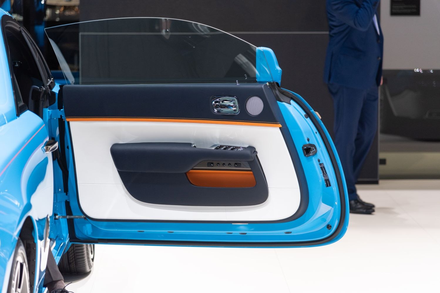 Luxury car interior door panel with blue, black, white, and orange accents.