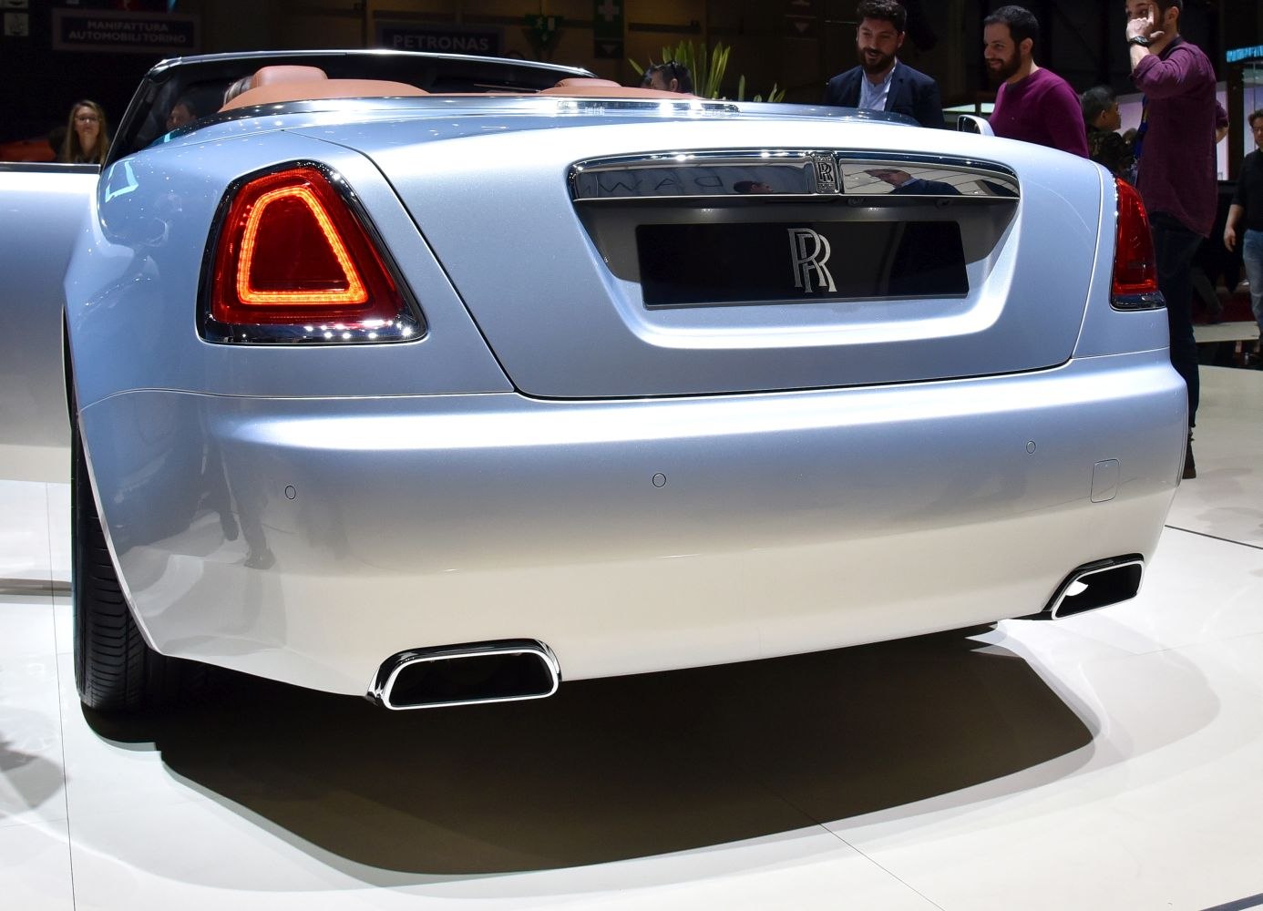 Distinctive triangular LED tail lights and dual exhaust at rear of luxury convertible.