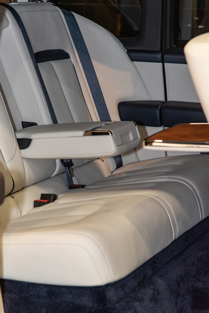 Luxury rear seats with armrest and wooden table in cream leather upholstery