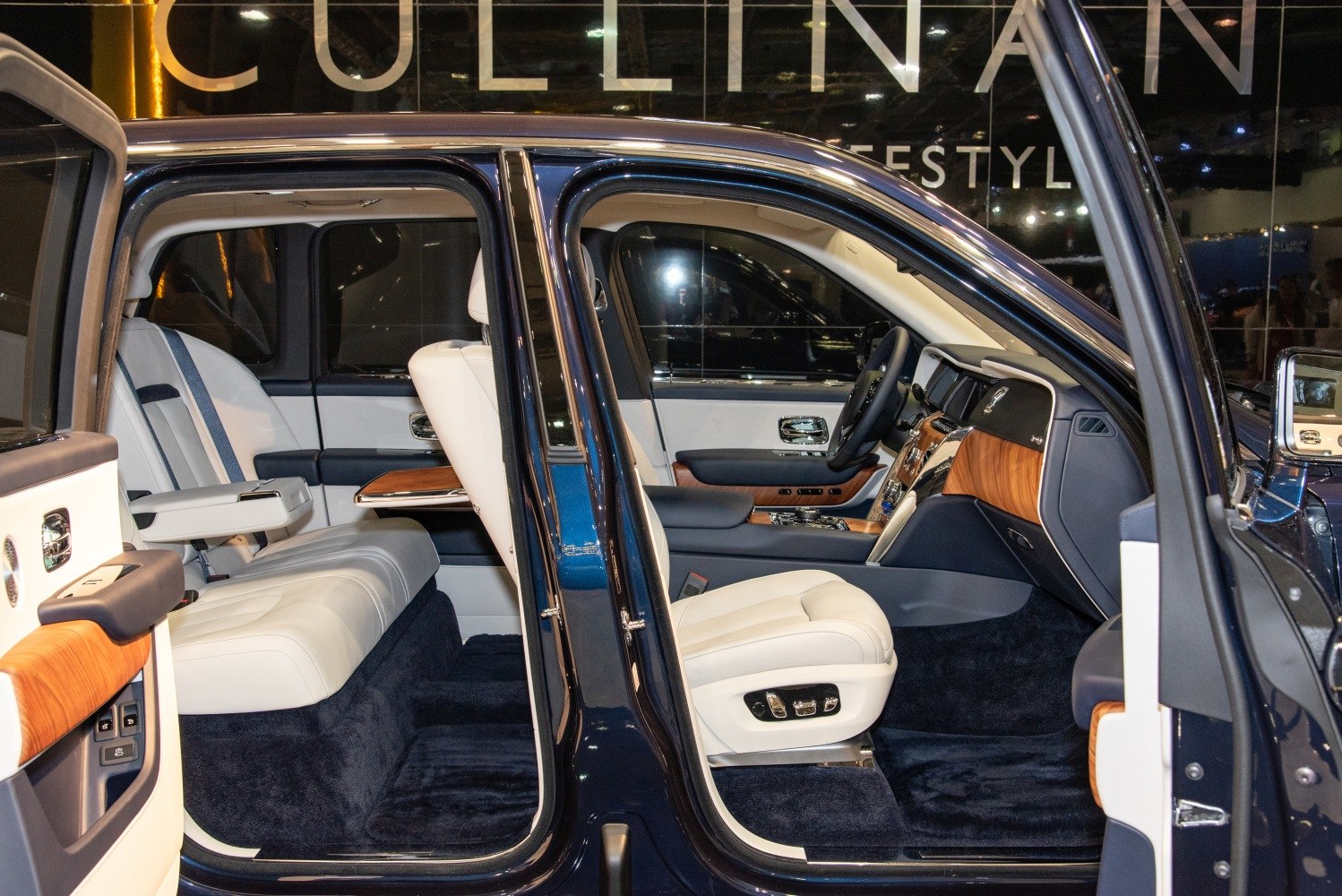 Spacious luxury car interior with white leather seats and wood accents