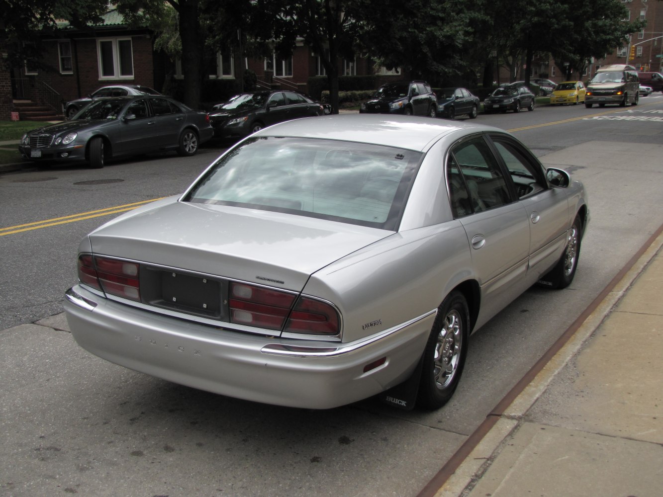 Rear view of a silver mid-90s sedan with classic tail lights and chrome trim
