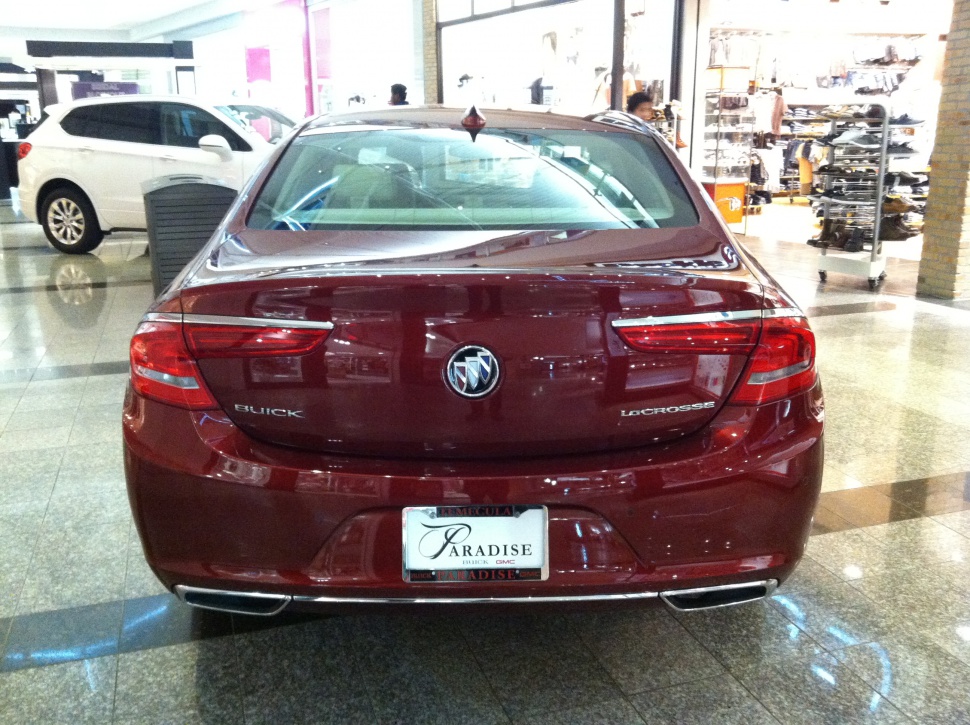 Rear view with tail lights, emblem, trunk, and dual exhaust tips