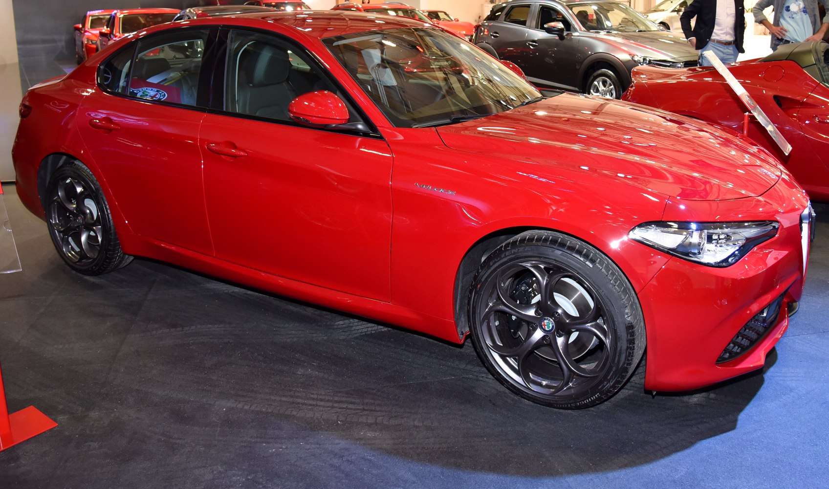 Red sports sedan with circular alloy wheels and sharp headlights