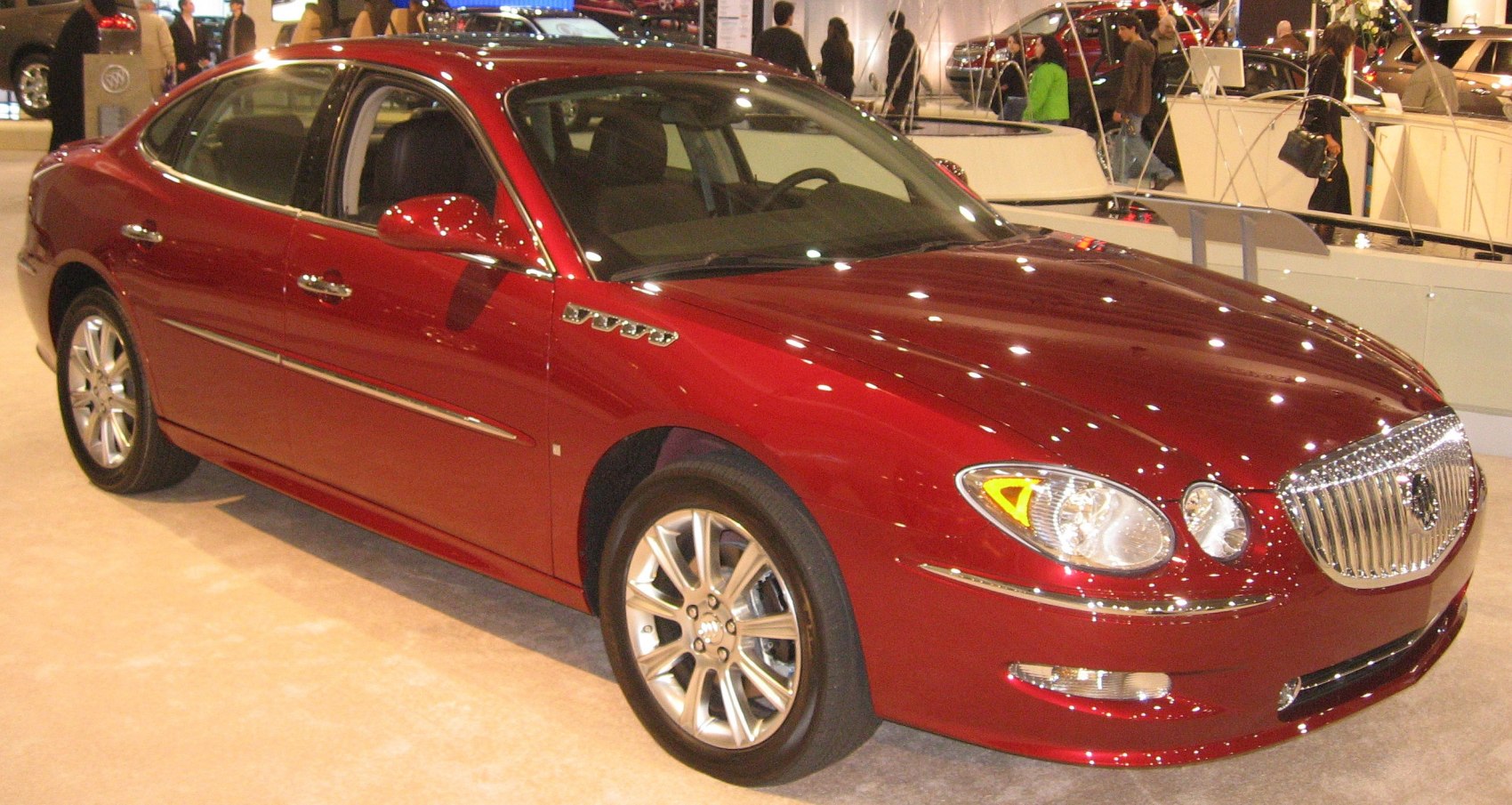 Red sedan with chrome-accented front and alloy wheels