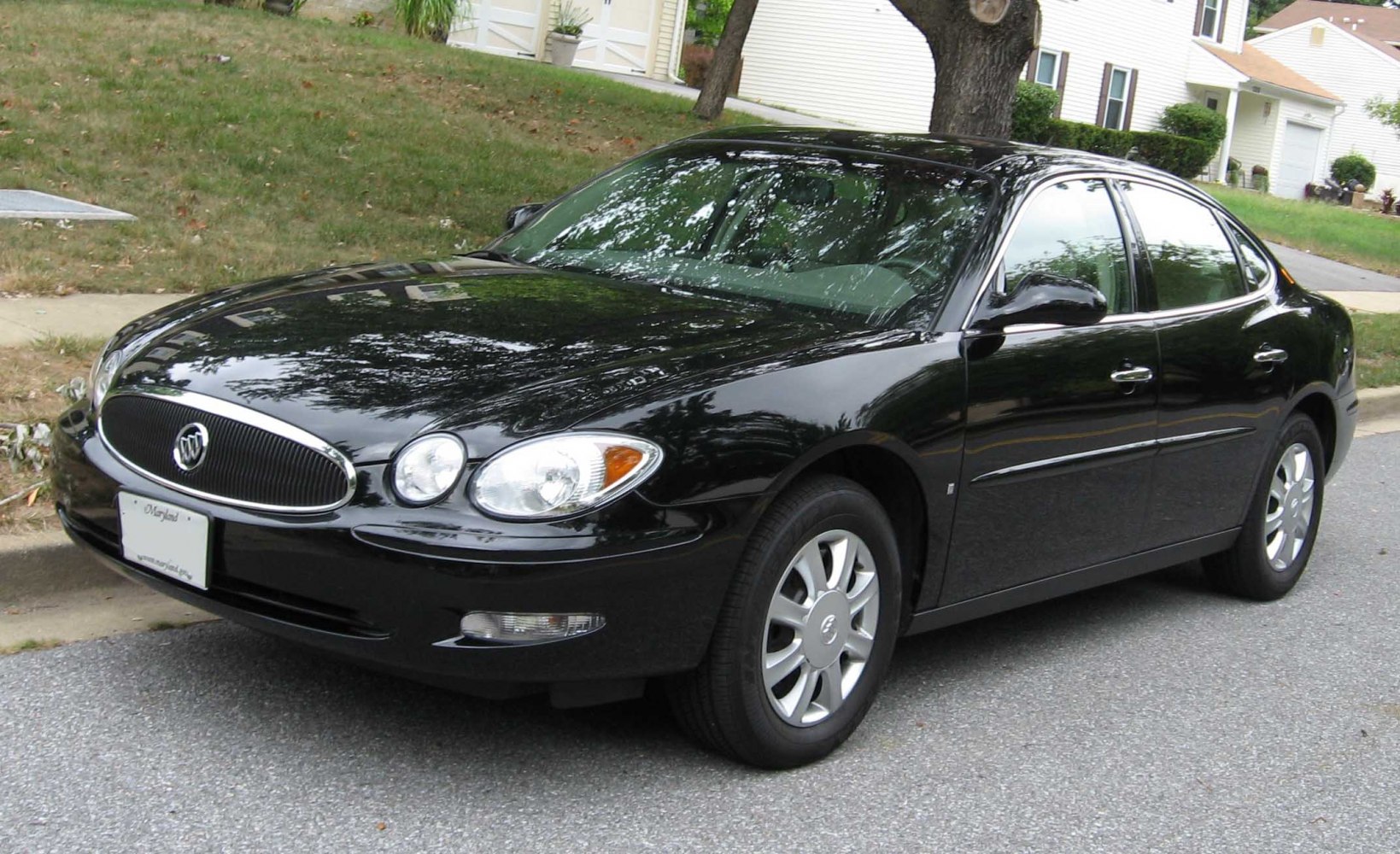 Black sedan with dual round headlights and chrome-trim front grille