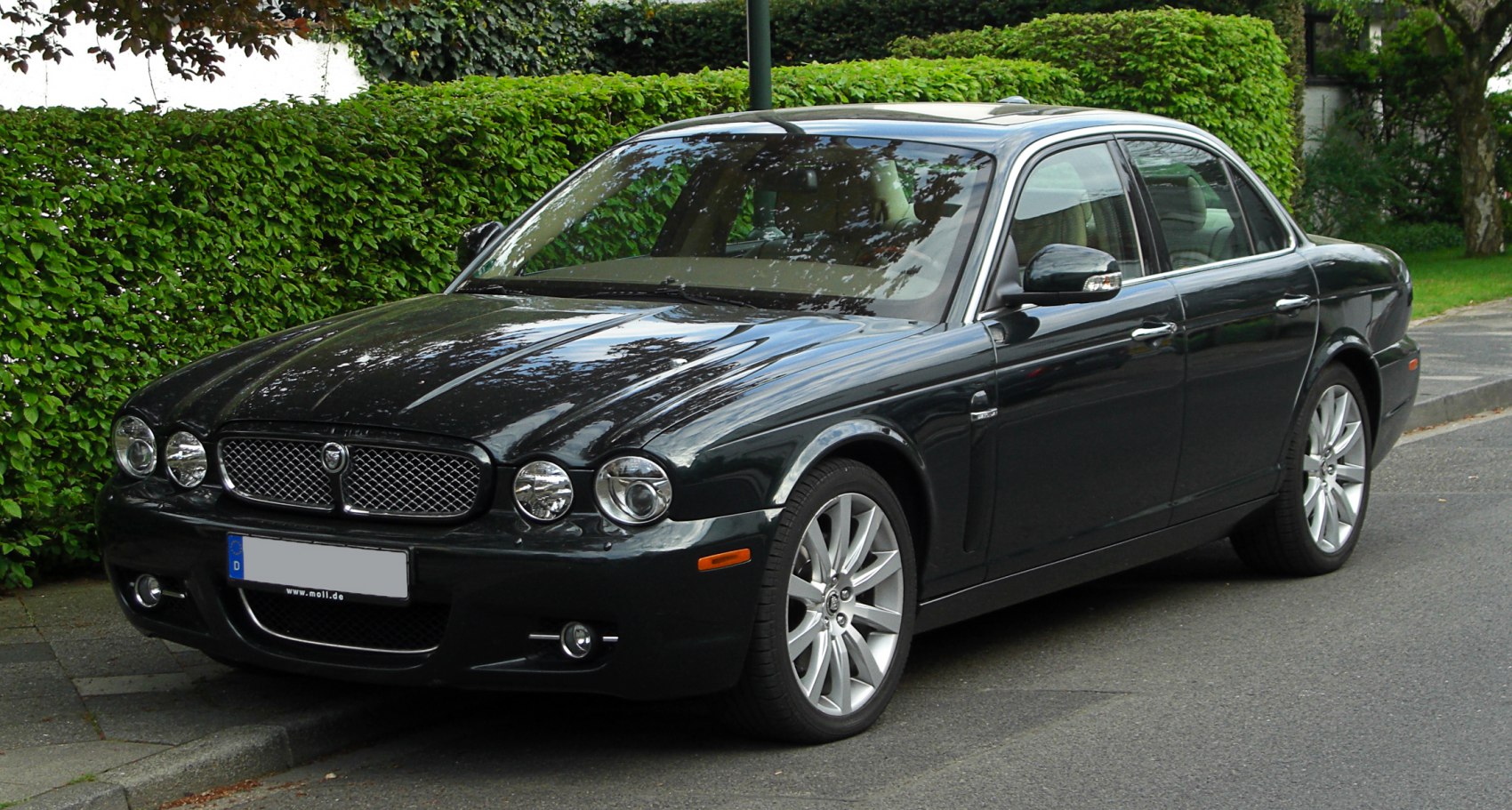Luxury sedan with quad round headlights and mesh grille