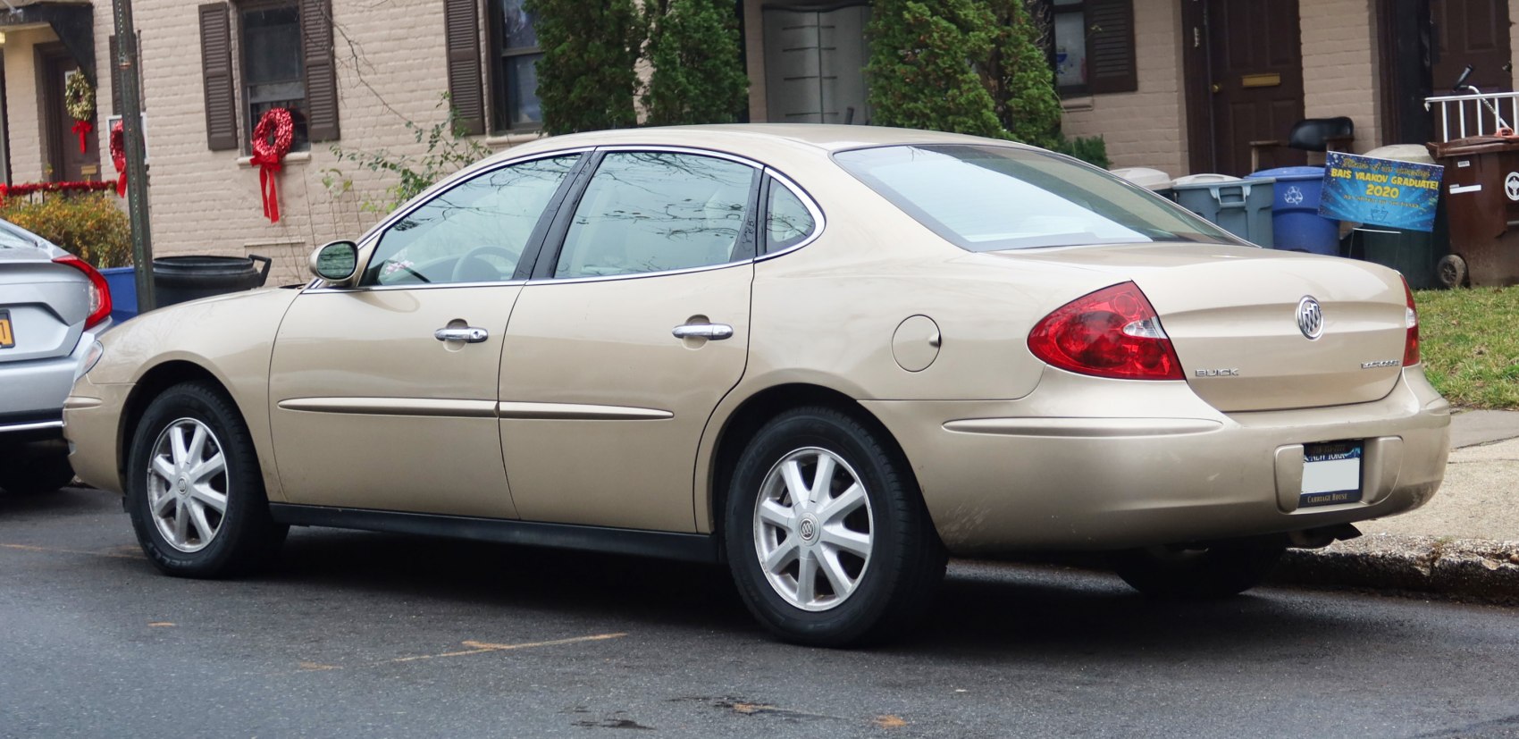 Rear side view of a beige 2000s sedan with alloy wheels and smooth contours