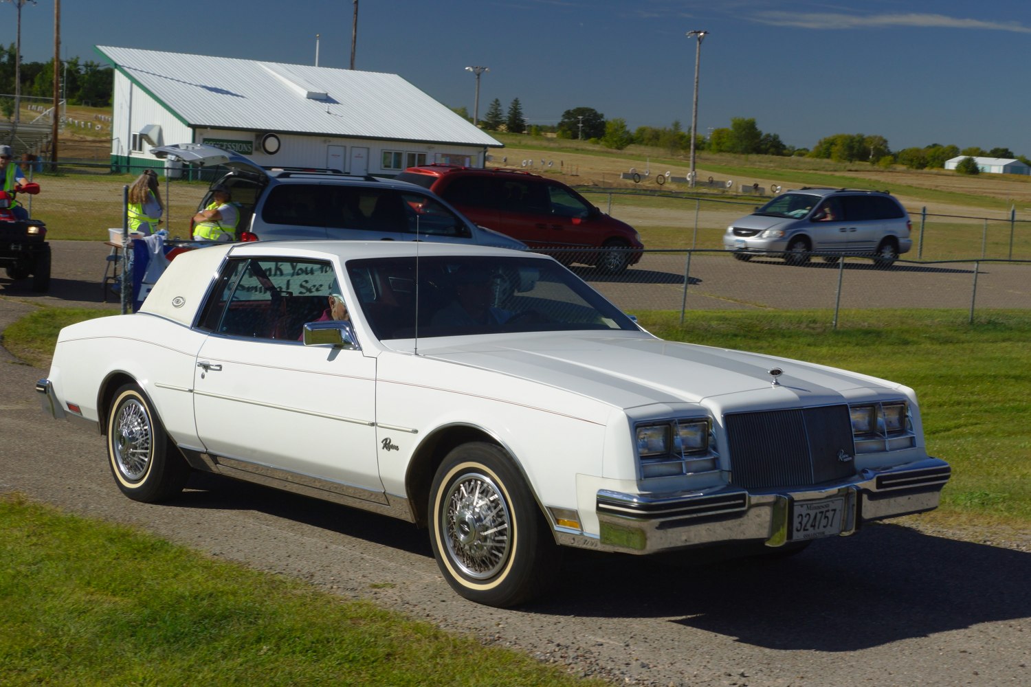 White two-door coupe with wire spoke wheels and vinyl roof