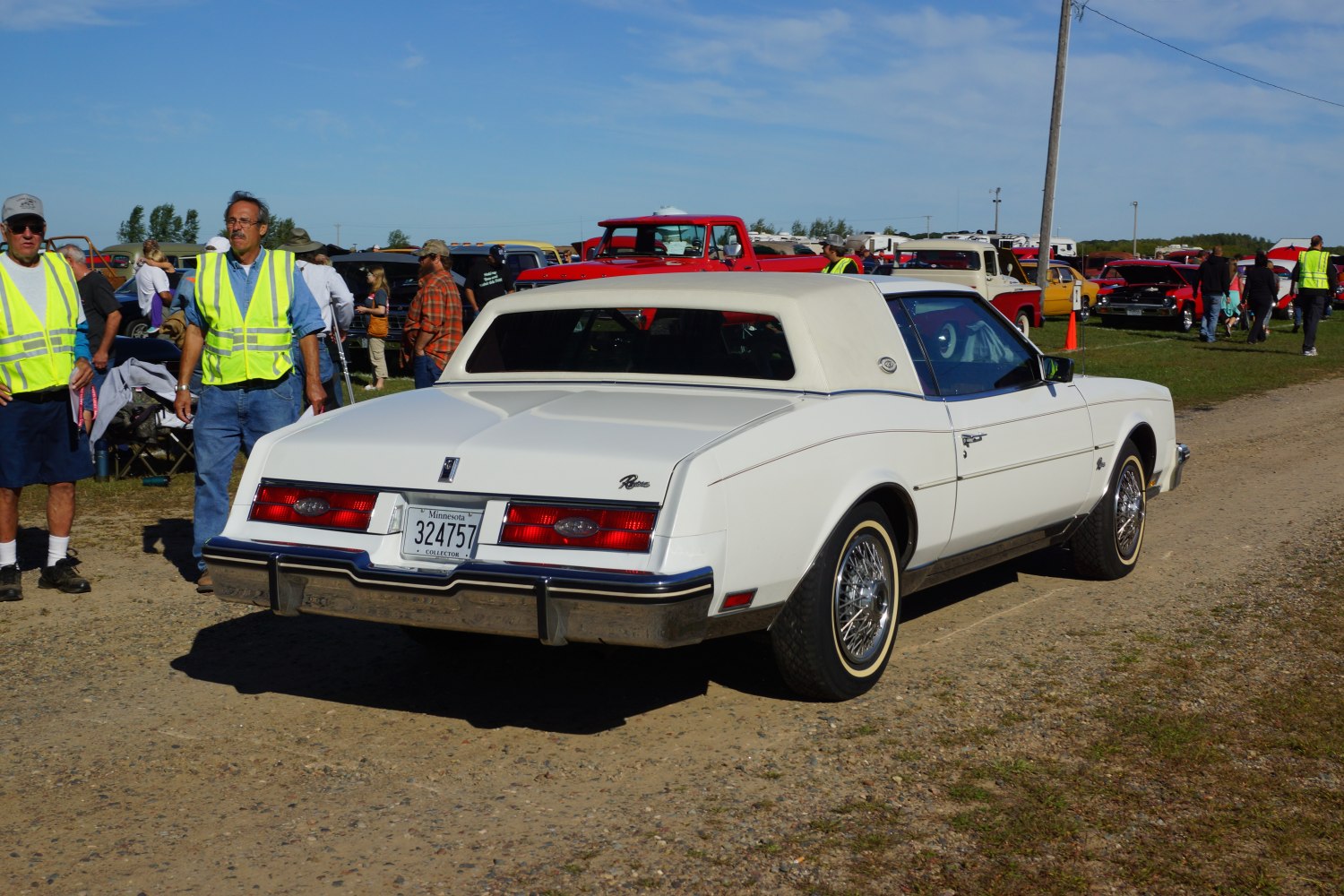 White luxury coupe with vinyl roof and wire wheel covers