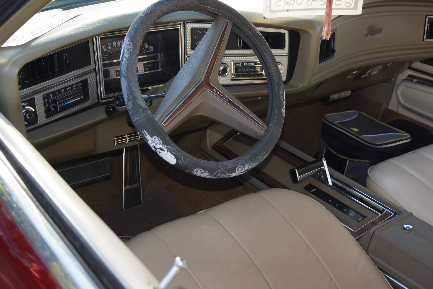 Vintage steering wheel, dashboard, and center console gear shifter.