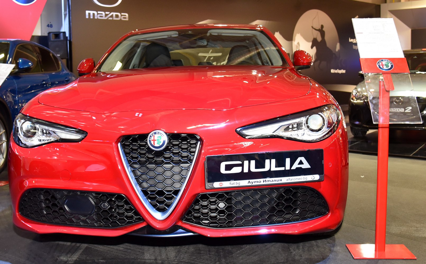 Close-up front view with triangular grille and sharp LED headlights