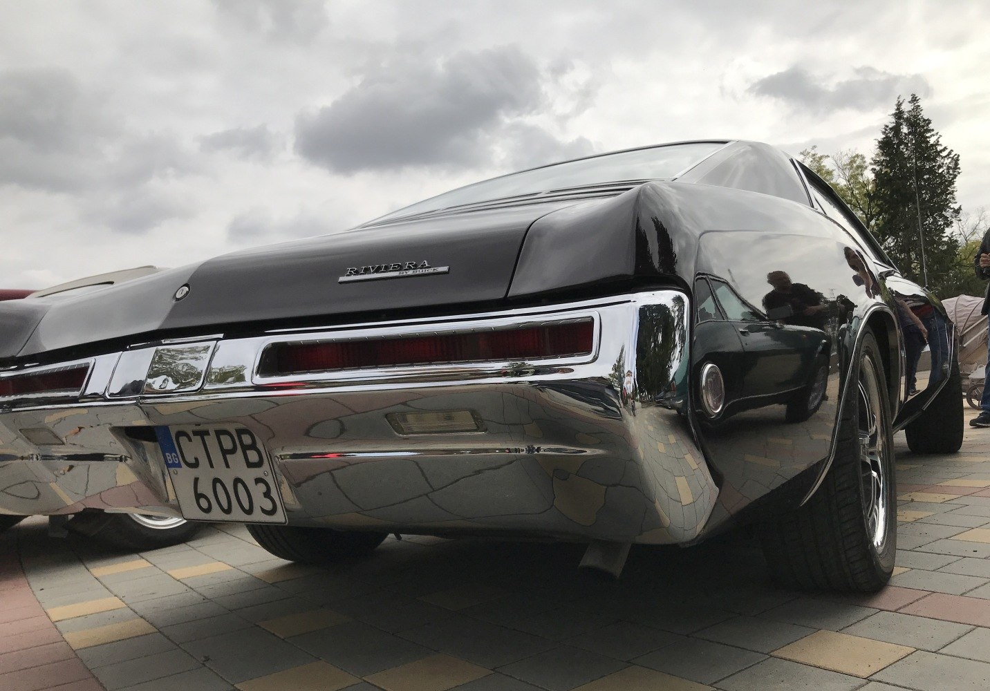 Rear view of a vintage car with prominent chrome bumper and glossy body finish