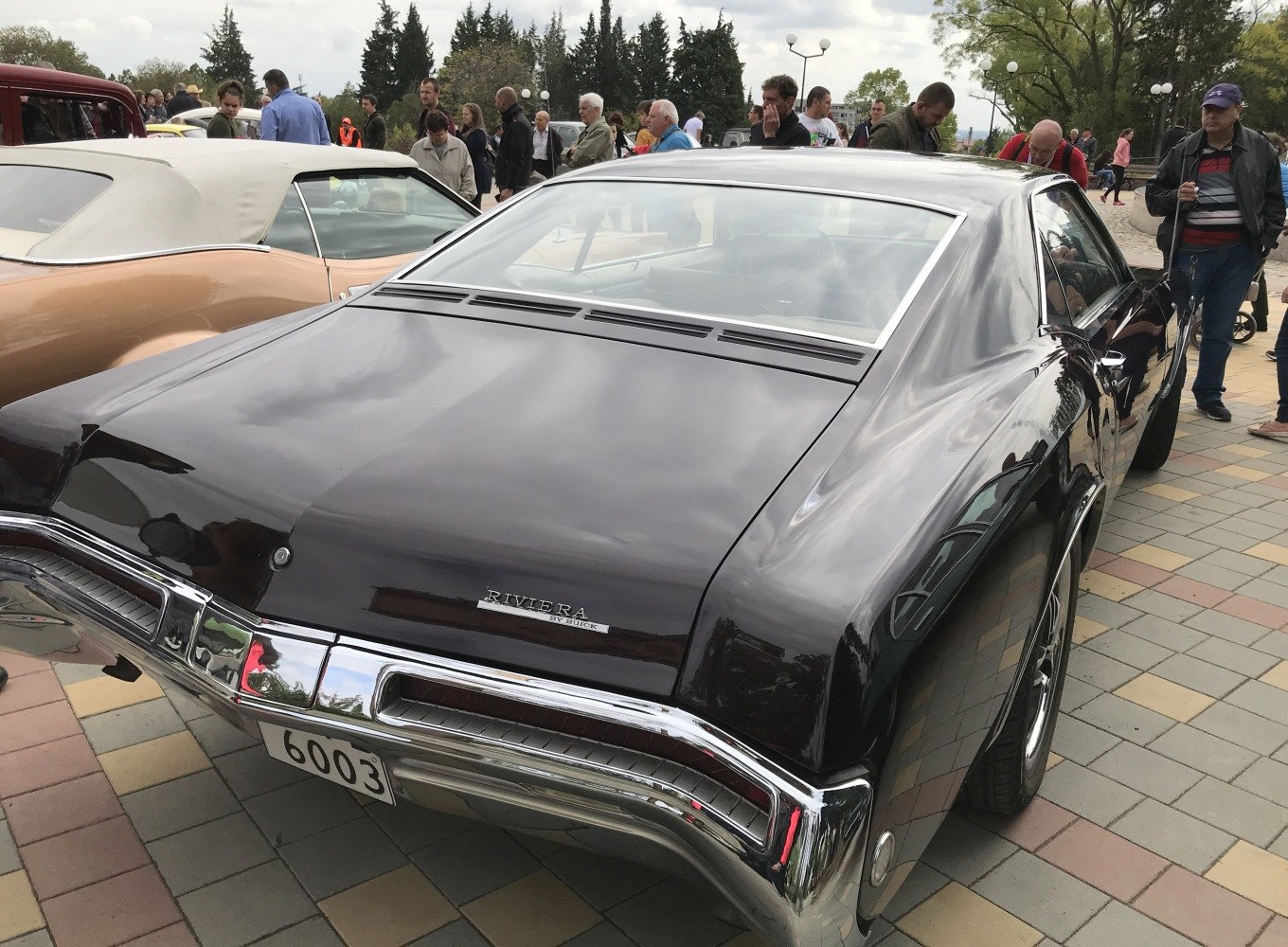 Rear view of a classic vintage car with chrome bumper and smooth body lines.