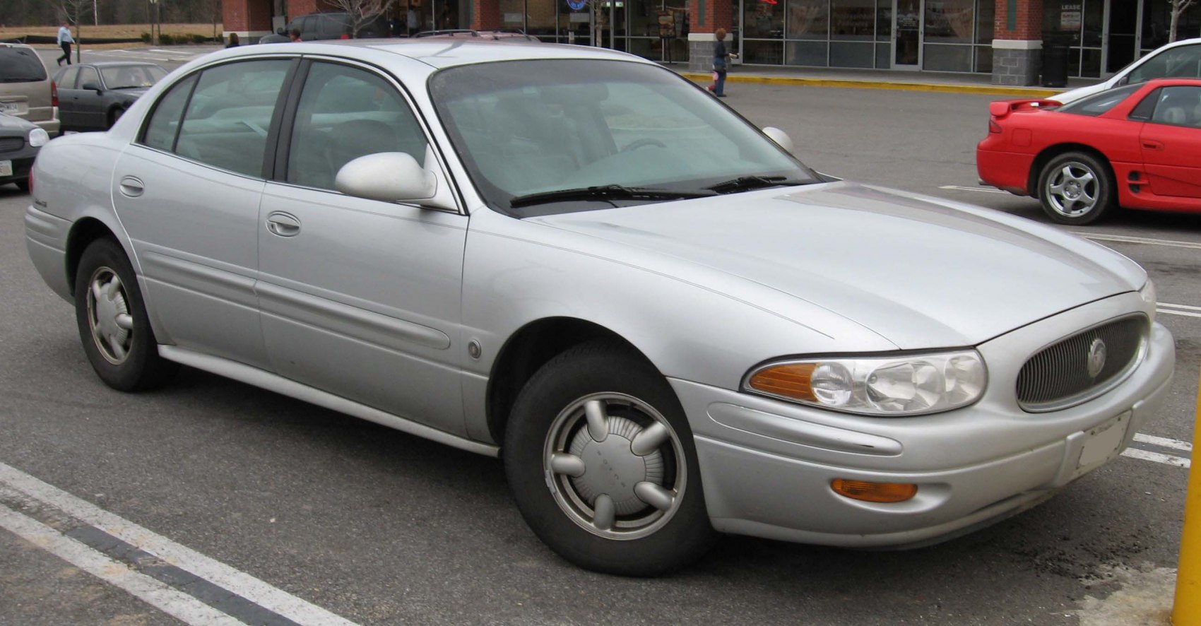 Silver 4-door sedan with rounded headlights and vintage hubcaps