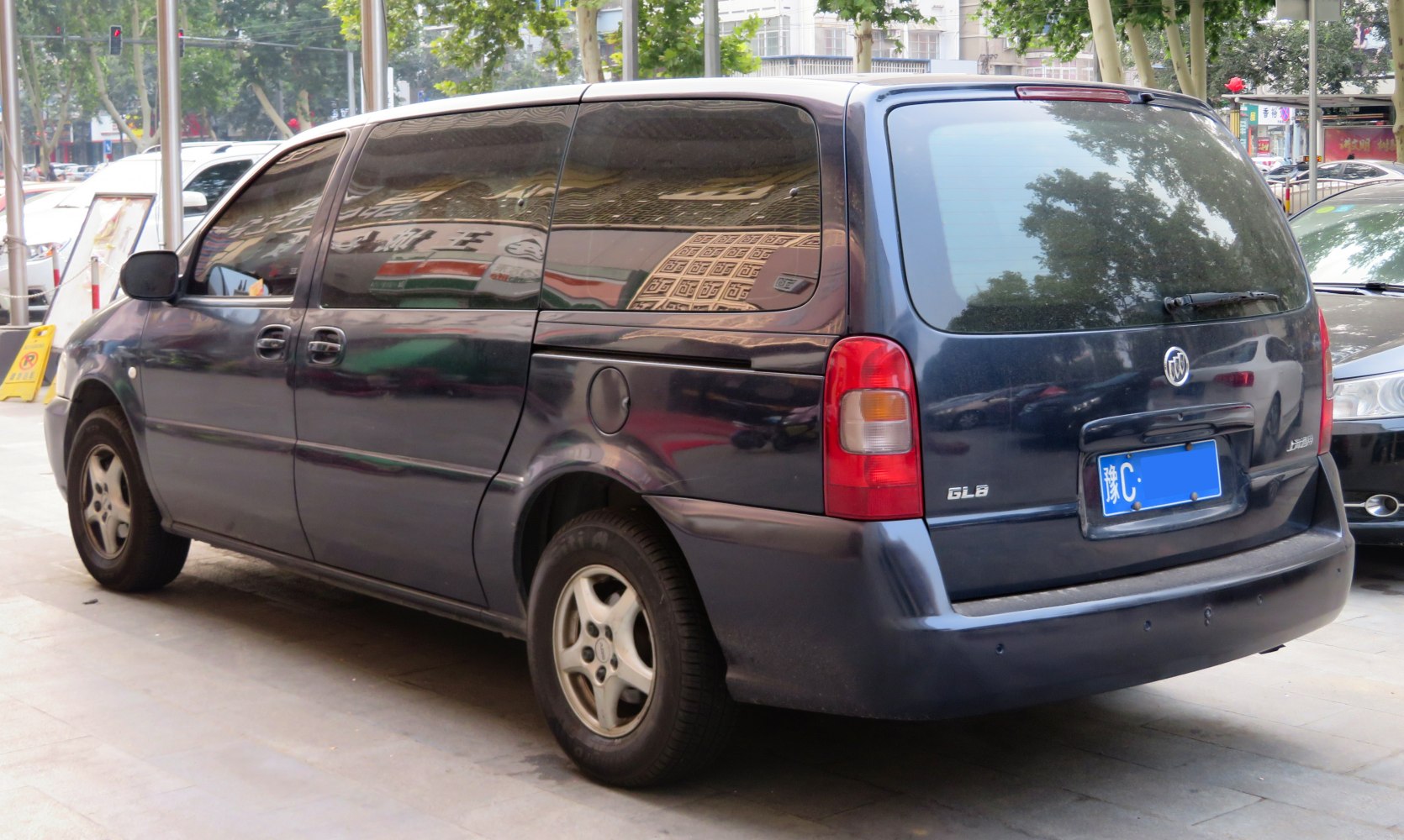Rear and side view of a minivan with sliding doors and tinted windows