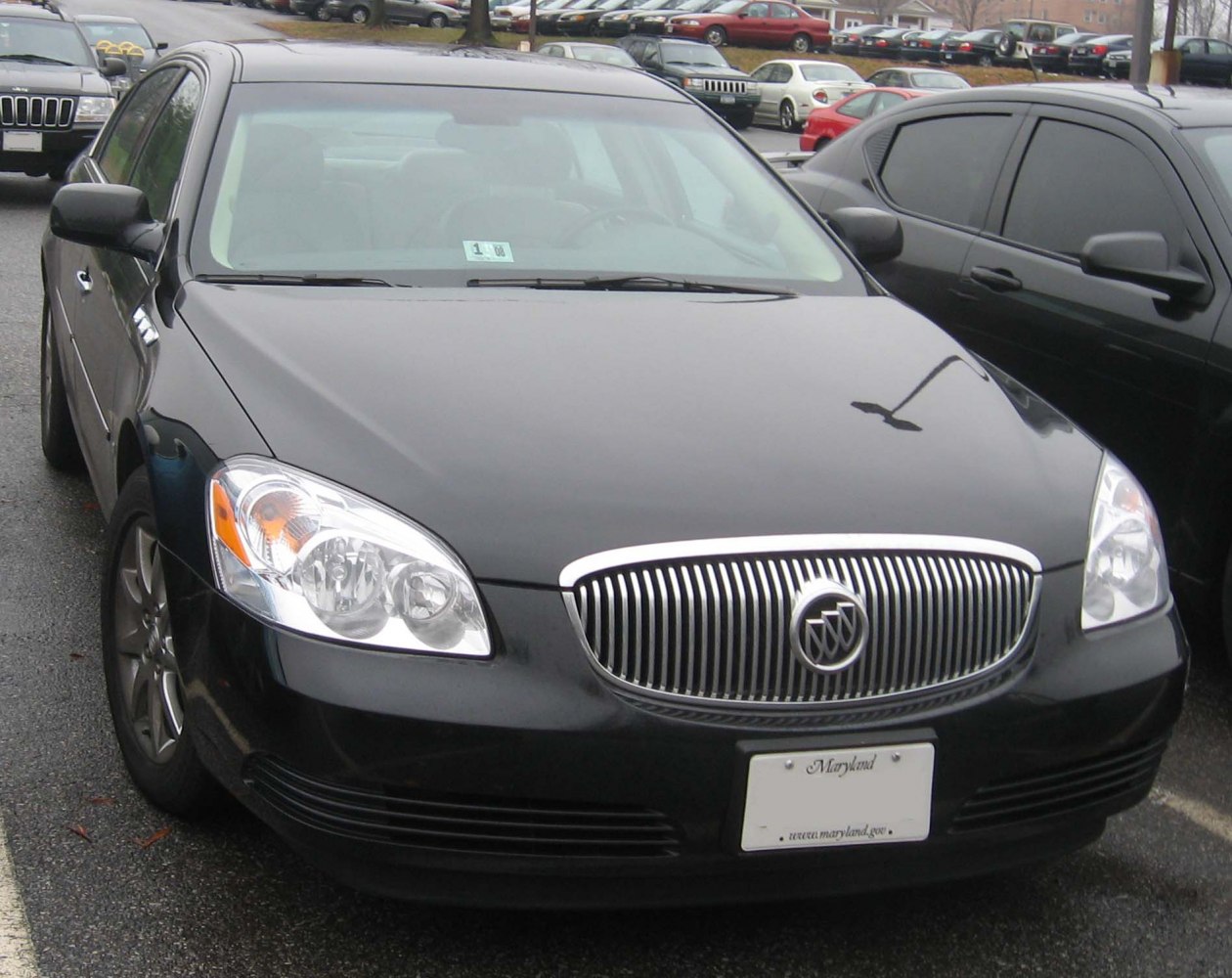 Front view showing chrome grille and clear headlights on a black sedan.