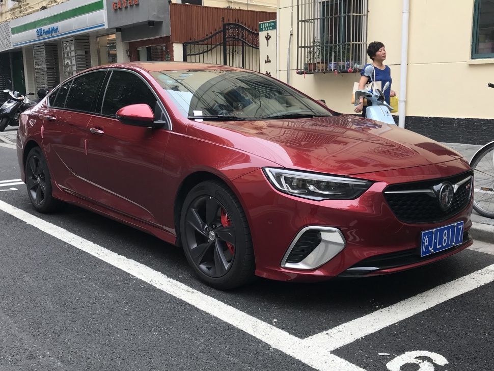 Red sedan with sporty front end and dark alloy wheels