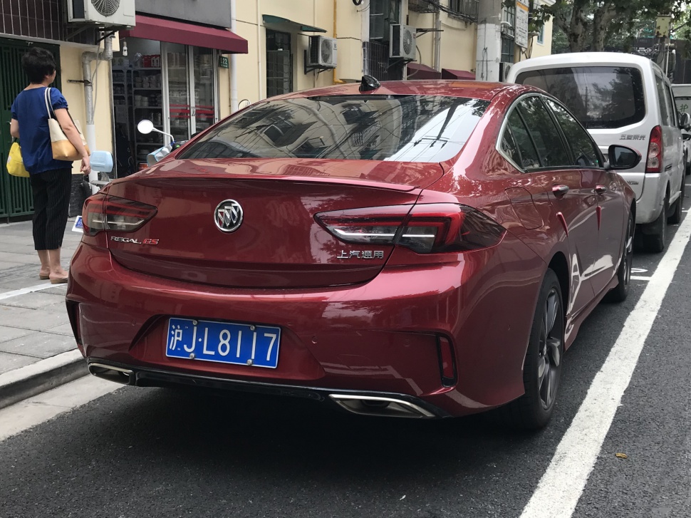 Sporty tail lights and dual exhaust system on a red sedan rear.