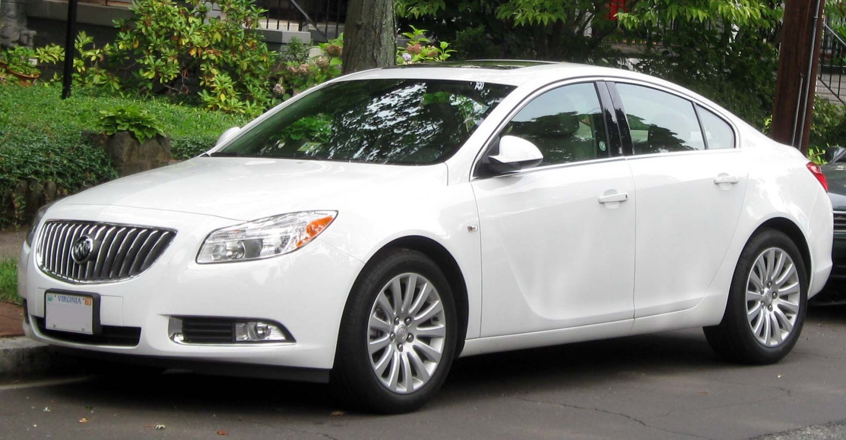 White mid-size sedan front side view with alloy wheels and chrome grille