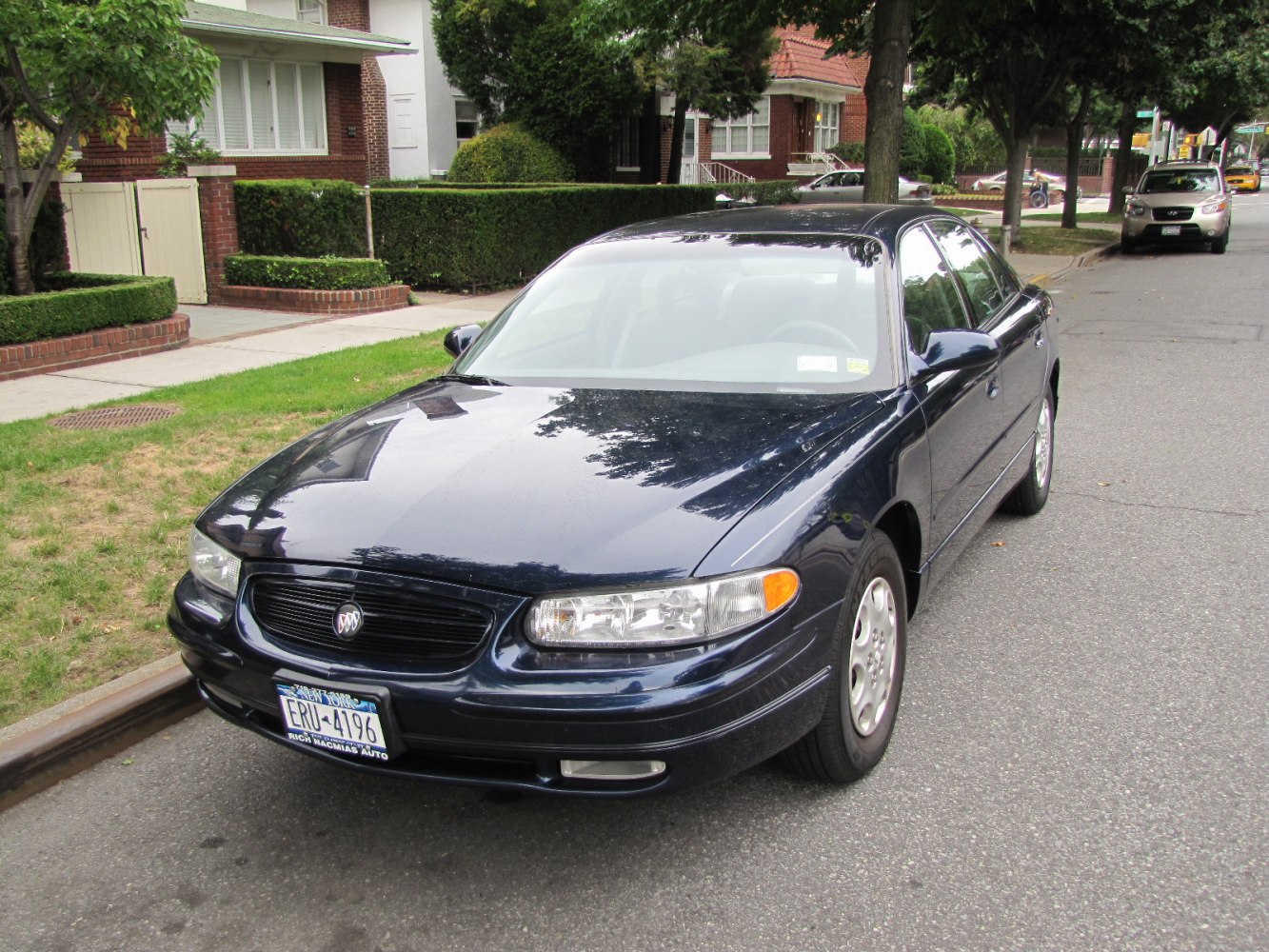 Front view with rounded headlights and black horizontal grill on smooth sedan body.