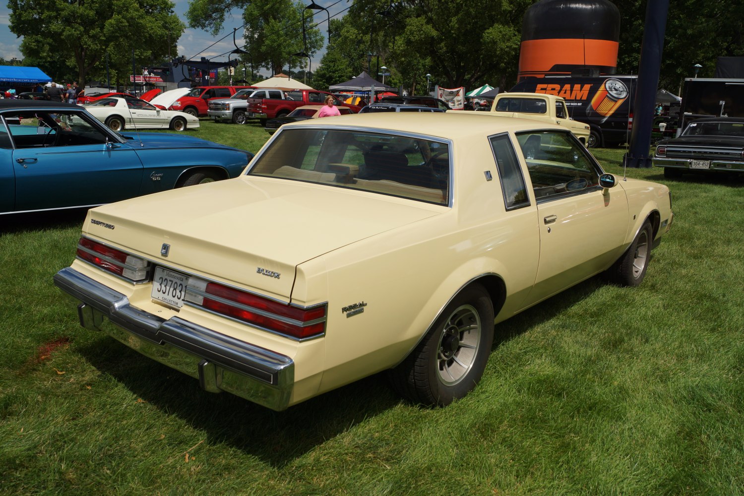 Beige classic coupe with distinct taillights and vintage design.